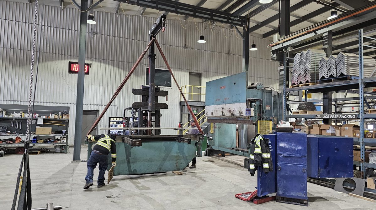 Large industrial machine protected in plastic as it is moved with a heavy forklift