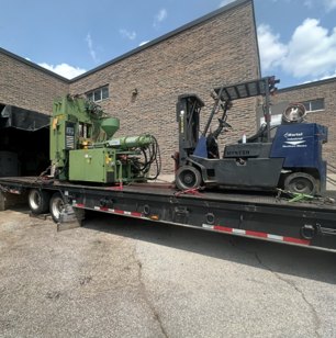 Industrial forklift and machinery on a transport trailer